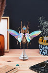 Colorful Paper Atlas Beetle craft by Assembli with vibrant rainbow wings, assembled from paper for creative arts and crafts projects.