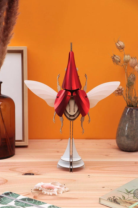 Large Paper Hercules Beetle craft by Assembli featuring red translucent wings and detailed body, perfect for creative projects.
