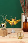 Large paper stag beetle craft by Assembli, featuring detailed gold-colored paper wings and body for creative arts projects.