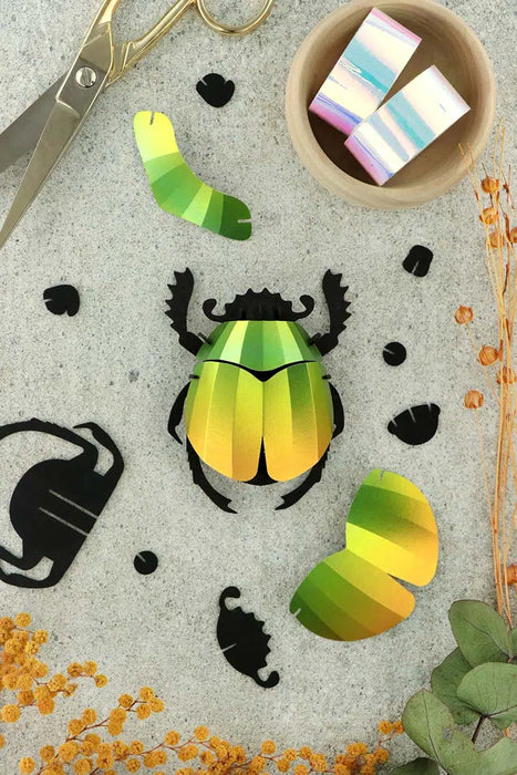 Assembli paper scarab beetle craft in vibrant mango color, detailed folded paper design, perfect for creative art projects.