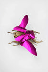 Large pink paper stag beetle craft by Assembli, featuring detailed wings and prominent mandibles, displayed on a white background.