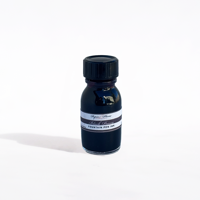 Bottle of Papier Plume black peony fountain pen ink with black ink inside, label visible on the glass container.