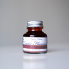 Papier Plume Cajun Flamingo fountain pen ink in a 30ml bottle with vibrant pink-orange ink inside.