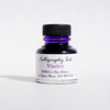 Violet bottled calligraphy ink by Papier Plume with a glass ink bottle and calligraphy pen on a white background.