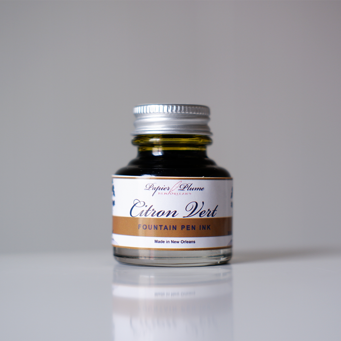 Papier Plume fountain pen ink in vibrant citron vert green, shown in a glass bottle with a black cap.