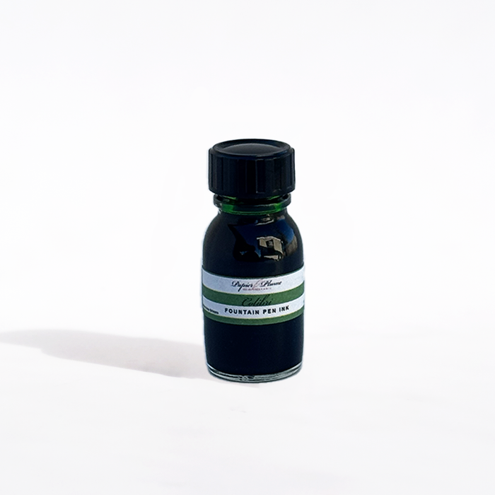 Bottle of Papier Plume Colibri fountain pen ink with a clear glass container and colorful ink inside.