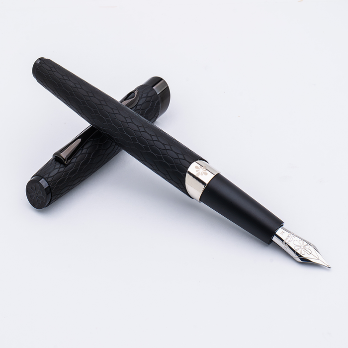 Matte black Diplomat Cobra fountain pen with sleek design and gold accents, shown resting on a white surface.