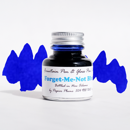 Papier Plume Forget-Me-Not Blue fountain pen ink in glass bottle with ink swatch and label, vibrant blue ink for writing and art.
