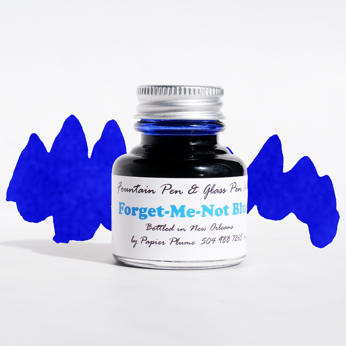 Papier Plume Forget-Me-Not Blue fountain pen ink in glass bottle with ink swatch and label, vibrant blue ink for writing and art.