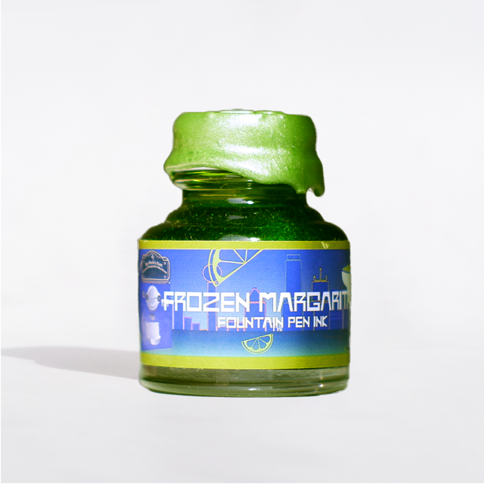 Papier Plume Frozen Margarita shimmer fountain pen ink in a bottle, featuring vibrant orange and shimmering accents.