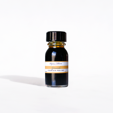Papier Plume Girasole fountain pen ink bottle, 15ml with vibrant yellow-orange ink visible in the clear glass container.