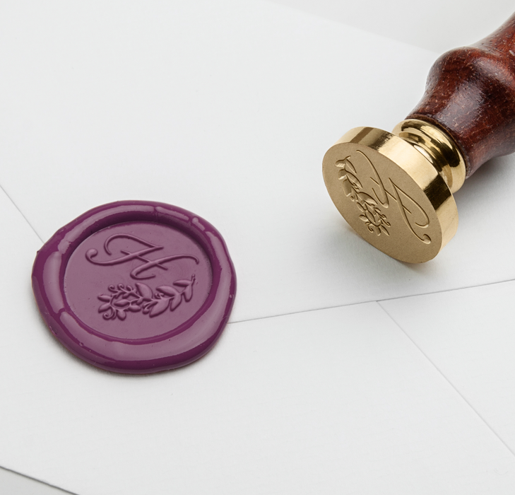 Wax seal with H-script monogram in black, featuring elegant Papier Plume Script Monogram design on smooth wax surface.