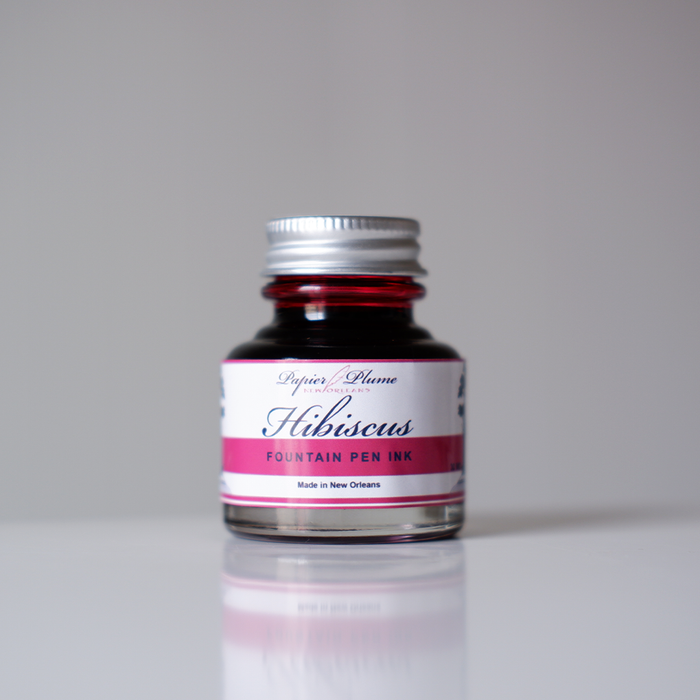 Bottle of Papier Plume fountain pen ink in Hibiscus color with floral label design.