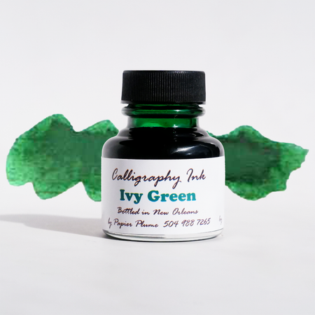 Ivy Green bottled calligraphy ink by Papier Plume in a glass bottle with a black lid, showcasing vibrant green ink for artistic writing.