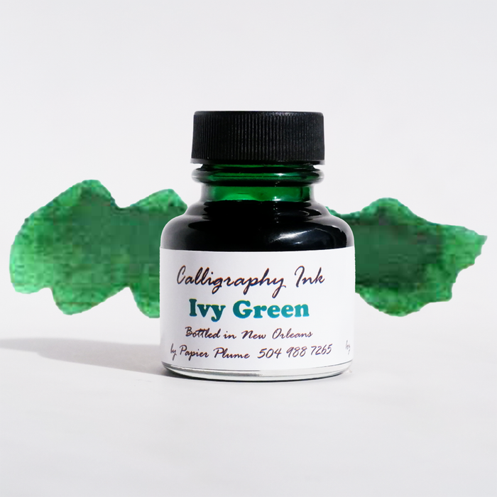 Ivy Green bottled calligraphy ink by Papier Plume in a glass bottle with a black lid, showcasing vibrant green ink for artistic writing.