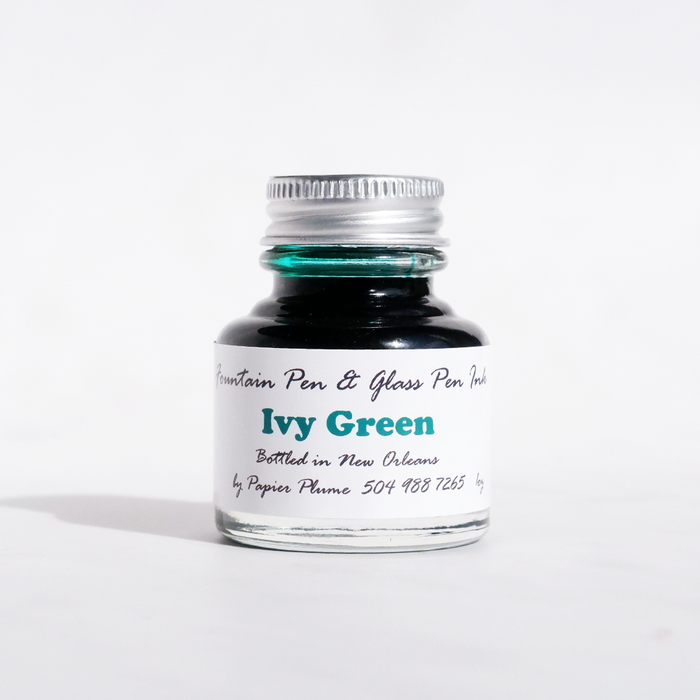 Papier Plume fountain pen ink bottle with Ivy Green ink, showcasing the rich green color in a sleek glass container.