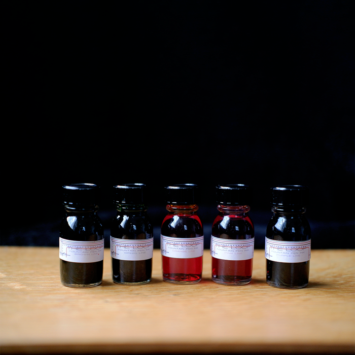 Papier Plume Loop Series fountain pen ink set with vibrant ink bottles in various colors on a white background.