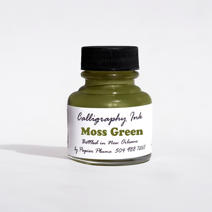 Moss green bottled calligraphy ink by Papier Plume, featuring a glass bottle of vibrant green ink for artistic writing and lettering.