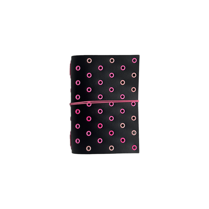 A black A6 bifold journal cover with pink grommets and Raven design by Imperfect Concepts.