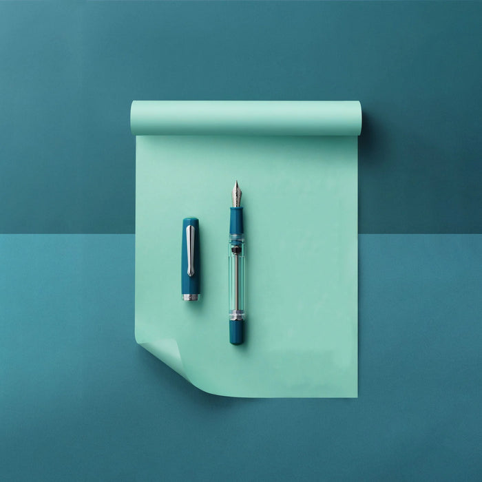 Nahvalur Original PLUS fountain pen with aquamarine-colored barrel and gold accents, showcasing elegant and smooth writing design.