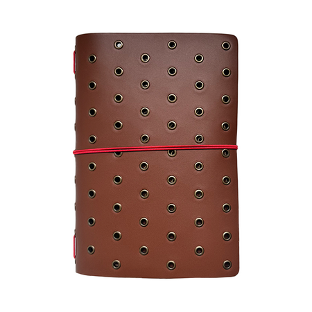Imperfect Concepts Niko B6 trifold journal cover in chocolate leather with bronze grommet accents.