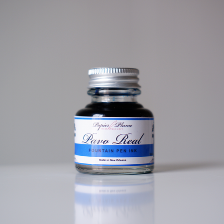 Papier Plume Pavo Real fountain pen ink bottle with vibrant blue and green ink, featuring a decorative label.