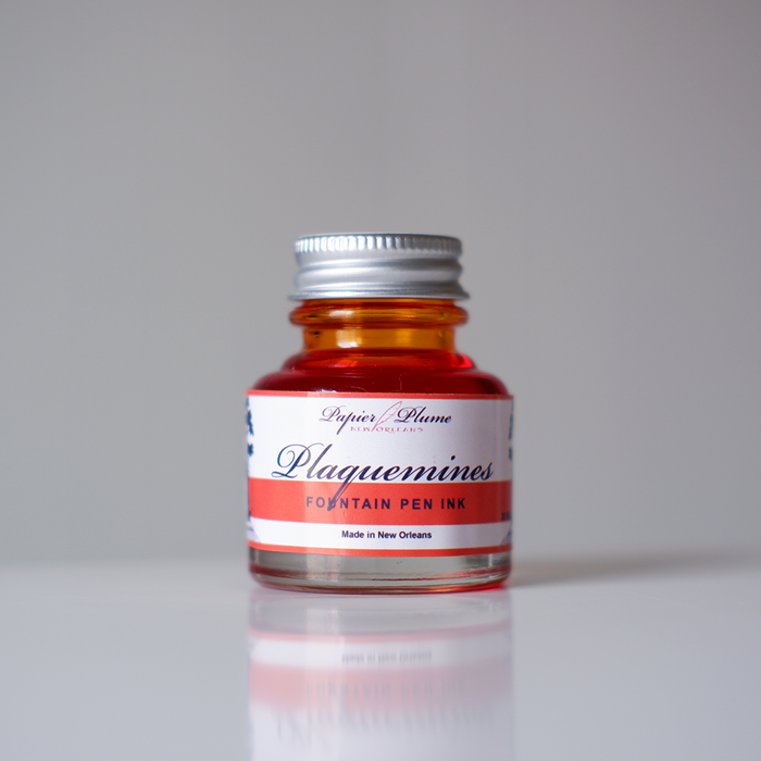 Papier Plume Plaquemines fountain pen ink bottle with vibrant ink inside, designed for elegant writing and calligraphy.