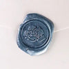 Brass wax seal with rose symbol by Papier Plume, featuring intricate floral design for sealing and decorative purposes.
