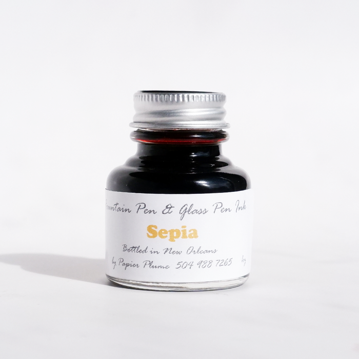 Sepia fountain pen ink bottle from Papier Plume, featuring classic ink color in a glass container with a label.