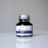 Papier Plume Sheepshead fountain pen ink in a 30ml bottle with vibrant blue ink visible.