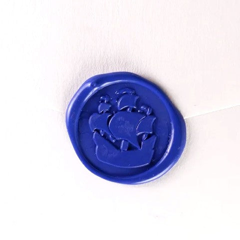 Brass wax seal stamp with ship symbol from Papier Plume, showing intricate maritime design on the seal's surface.