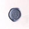 Brass wax seal stamp with intricate symbol design, used for sealing documents and adding a decorative touch.