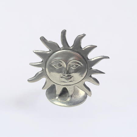 Le Potier D'Étain pewter sun-shaped pen rest stand for quill or writing instruments on a smooth surface.