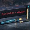 Esterbrook x BUNGUBOX Kingfisher Limited Edition Estie fountain pen with vibrant blue and gold accents on a white background.