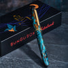 Esterbrook x BUNGUBOX Kingfisher Limited Edition Estie fountain pen with a vibrant blue and gold design on a white background.