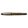 Esterbrook Estie fountain pen with gold fittings resting on a botanical garden background, showcasing its elegant design and detailing.