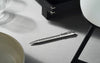 Caran D'Ache Platinum-Coated Ecridor Avenue rollerball pen with detailed close-up of the elegant ballpoint tip and platinum finish.