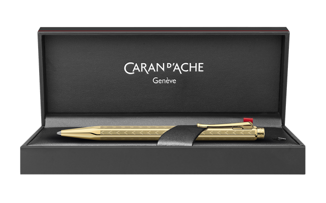Caran D'Ache Gilded Ecridor Chevron ballpoint pen with gold accents and intricate chevron design, close-up detail image.