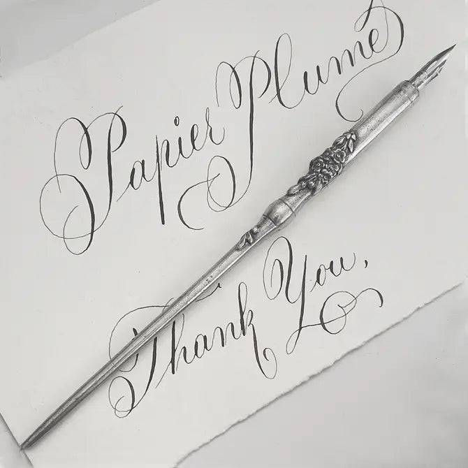 Le Potier D'etain pewter calligraphy dip pen with fleur-de-lys design, featuring a detailed handle and nib for elegant writing.