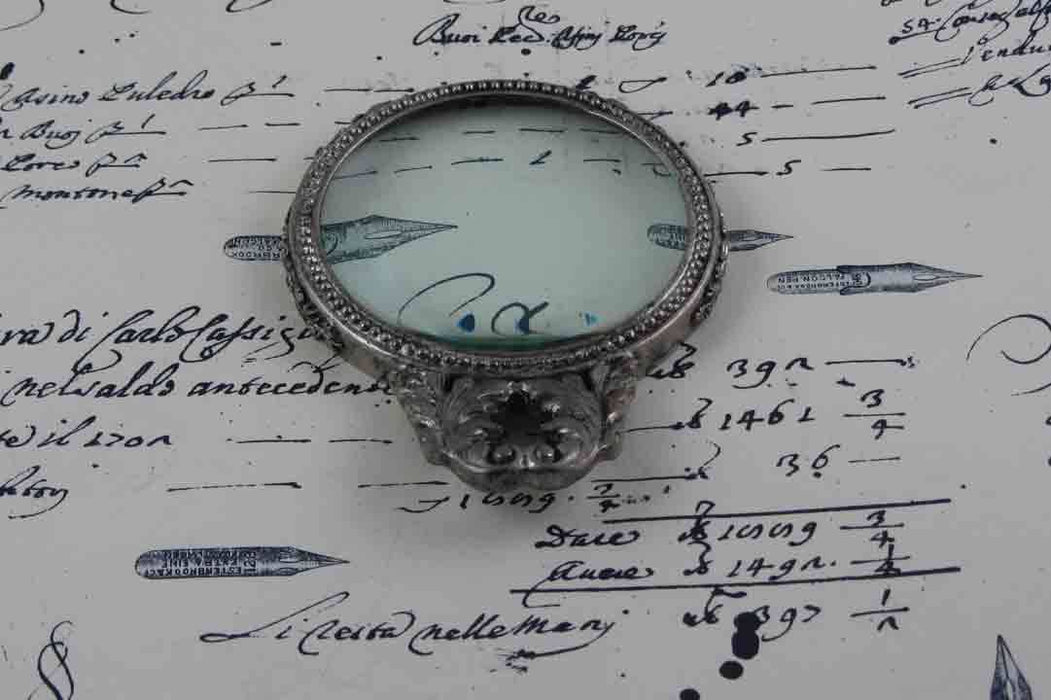 Large pewter magnifying glass with handle and acanthus detail by Le Potier D'etain, showcasing intricate craftsmanship and antique design.
