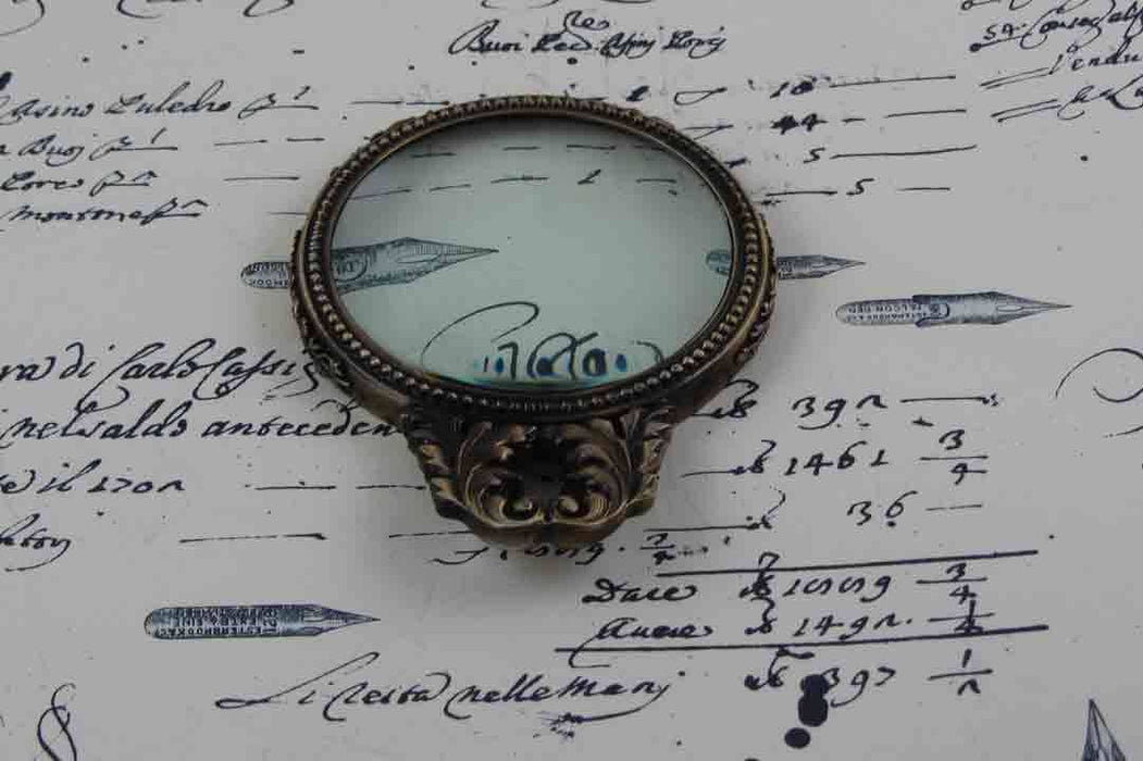 Large pewter magnifying glass with handle and acanthus design by Le Potier D'etain, showcasing intricate craftsmanship.