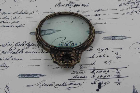 Large pewter magnifying glass with handle and acanthus design by Le Potier D'etain, showcasing intricate craftsmanship.