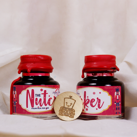 Papier Plume Nutcracker Fountain Pen Ink in a limited edition glass bottle with elegant labeling and vibrant ink color.